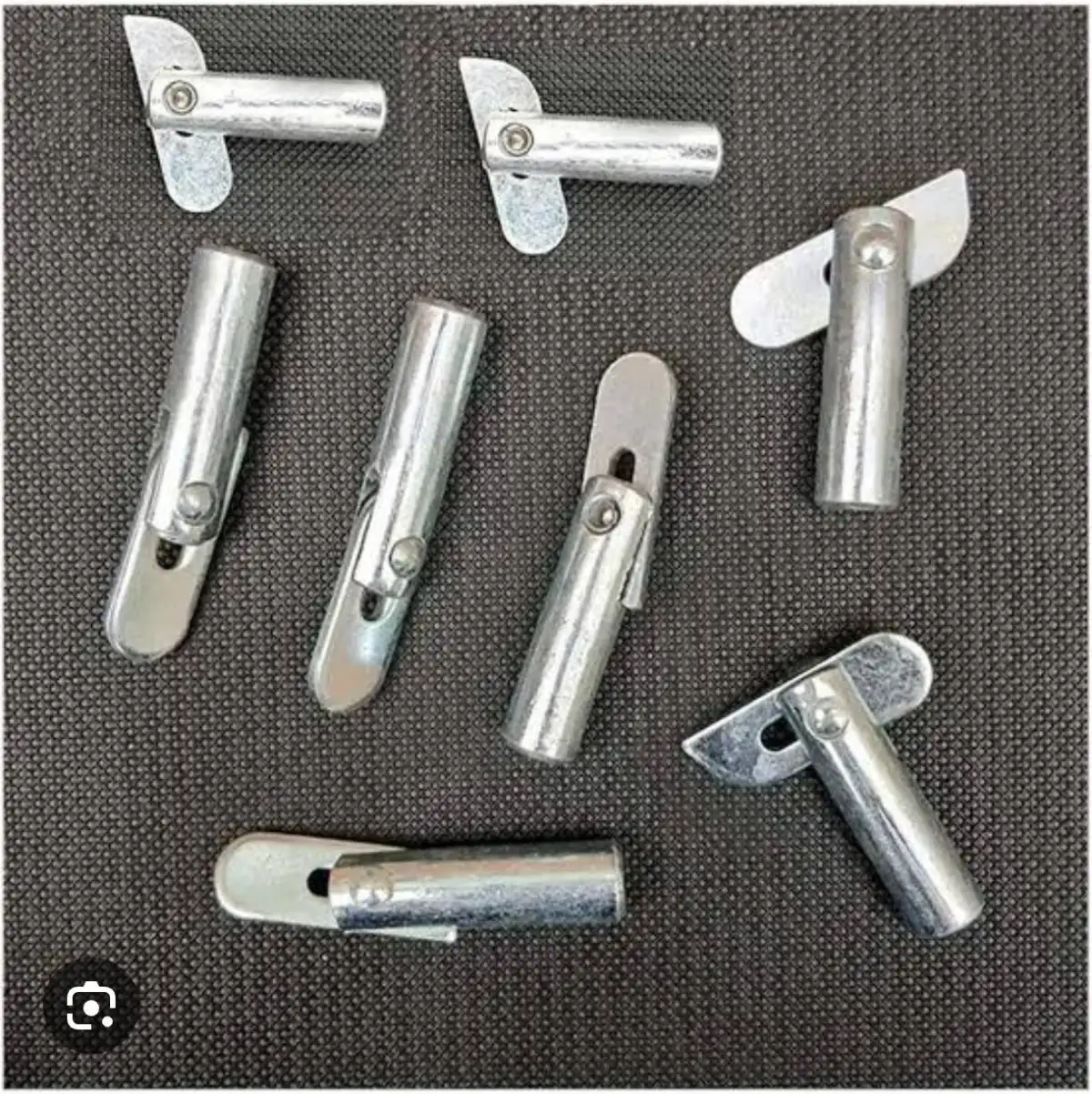 Industrial grade steel brace pin with a gravity-activated drop head welded onto a scaffolding vertical frame to lock a diagonal cross brace securely.